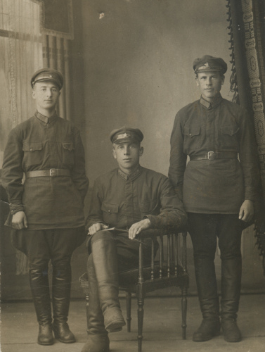 Красноармейцы слева и справа имеют шифровку с 
	номером части на петлицах, младший командир в центре - знаки различия и пулеметные значки (разновидность с наложенной звездой), 1930 г.